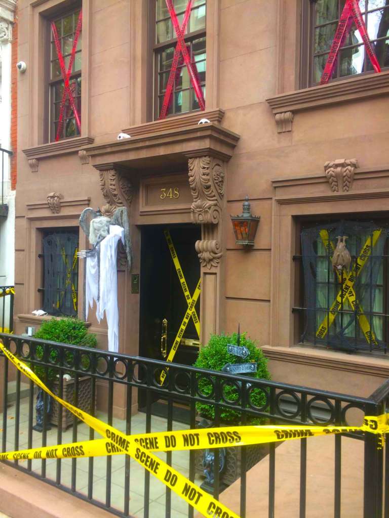Brownstone decorated for Halloween with yellow do not cross tape and a skeleton